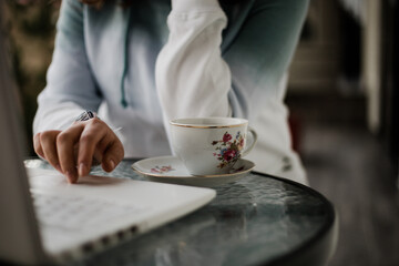 Taza de café al lado de una persona que trabaja en su computadora. Concepto de negocios, estudiante.