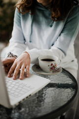 Obraz na płótnie Canvas Taza de café al lado de una persona que trabaja en su computadora. Concepto de negocios, estudiante.