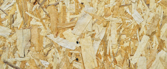 Texture of OSB panel board made of wood shavings, old pressed wood planks