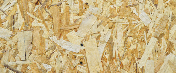 Texture of OSB panel board made of wood shavings, old pressed wood planks