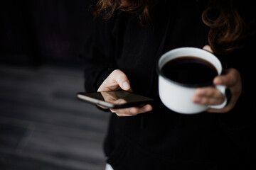 Mujer tomando café y con el celular en la mano. Concepto de estilos de vida, tecnología, negocios.