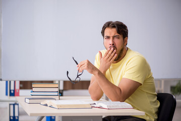Young male student preparing for exams in the classroom