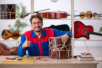 Young man repairing musical instruments at workshop