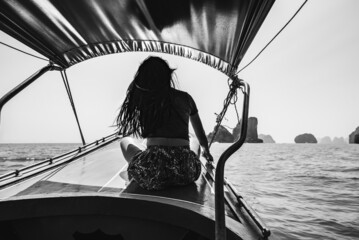 Woman riding a speedboat in the sea; visiting Ao Phang Nga National Park in Thailand