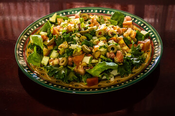 Um prato de salada sobre superfície reflexiva.