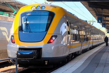 Plakat modern high-speed railway train in yellow-grey color on the platform