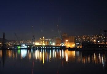 Fototapeta na wymiar Night cityscape of Rijeka reflections of city lights on the sea.