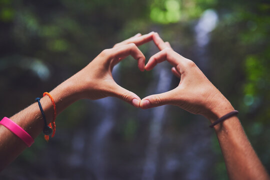 Travel is her true love. Shot of an unidentifiable young woman making a heart gesture with her hands in the jungle.
