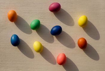 Many colored Easter eggs on wooden background, with sunlight and shadows, top view