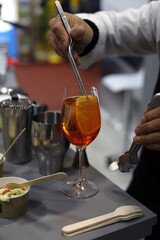 barman preparando coctel con una rodaja de naranja