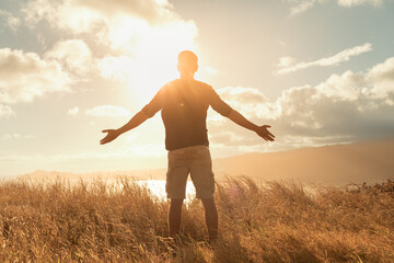 Feeling empowered and rejuvenated. Young man outdoors with arms in the air feeling strong and...