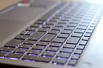 A picture of a computer keyboard with backlight, soft background
