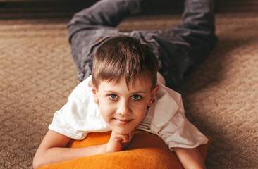 Teen boy sitting in living room smiling having rest, relaxing after education.