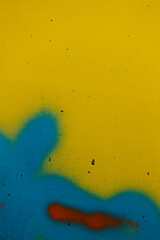 Fragment of the wall with yellow blue red colors graffiti painting. Part of colorful street art...