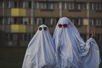 Funny image of two people in ghost costumes and sunglasses