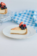 piece of cheesecake with berries on a white plate