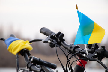 Yellow-blue flag of Ukraine on a bicycle in a city in Ukraine, a protest action, stop the war in Ukraine, a patriot of his country