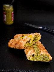 Pita mit Basilikumpesto gefüllt mit einem messer auf dunklen untergrund