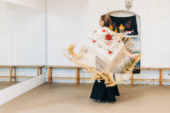 Flamenco woman dancer on her back with manila shawl in motion