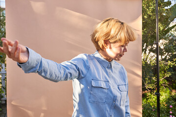 woman with arm extended by wall