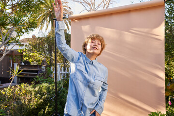woman with raised arm by wall
