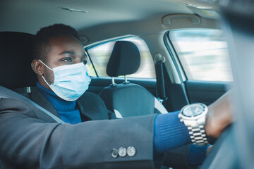 African business man driving a car with wearing medical mask for protection corona virus or Covid-19