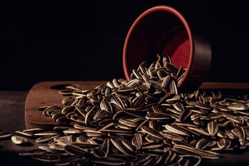 Sunflower seeds in a inverted bowl closeup on the old kitchen table, selective focus.