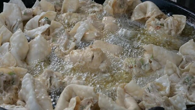 Cooking Baso Tofu Goreng (Batagor) with boiling oil.