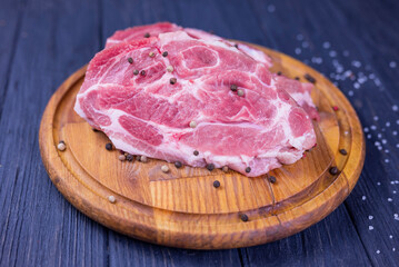 a piece of raw pork meat on a wooden board