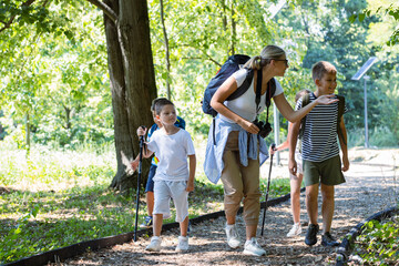 Group of children hiking in the forest with their teacher.They learn about nature and wildlife.	