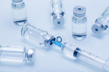 Closeup of medicine or injection vials with liquid and a syringe isolated on a white background