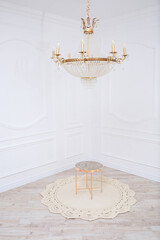 Handmade carpet knitted from natural threads, parquet, natural cotton. Beige handmade carpet. Interior solution for a house or apartment. Crystal Chandelier