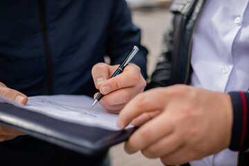 Contract signing close up shot. Customer sign papers in dealership office, client buying car or purchasing property