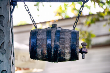 A barrel of beer is suspended in the air at the entrance to the cafe. - obrazy, fototapety, plakaty