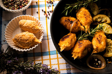 panierte muslitos mit rosmarin, zwiebeln und zitrone in einer pfanne