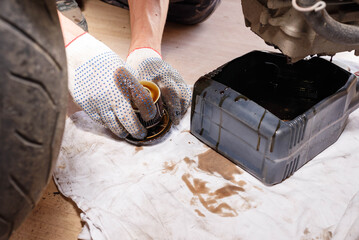 The process of draining oil from a motorcycle engine. Engine oil upgrade.