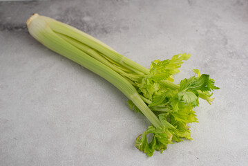 Fresh celery leaves and stalks on grey background. Food ingredient for healthy eating lifestyle