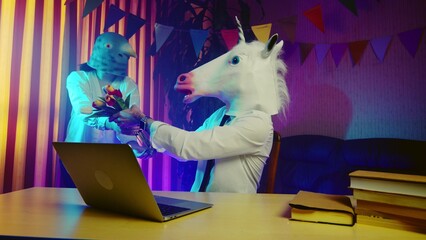 A woman in a pigeon mask is dancing in the background, and a young man in a unicorn mask is sitting...
