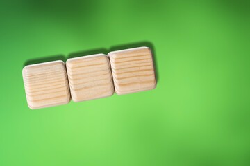 Three wooden cubes on green background