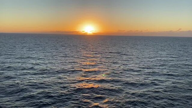 Video of sunset on the ocean. Watching the sunset over the ocean is the best way to experience it. The sun is setting with the vast, open ocean right below it. Sunrise as seen from a cruise ship.
