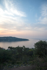 Fototapeta na wymiar Panorama lors d'un lever de soleil sur la presqu'île du Cap Ferrat depuis la petite batterie de Nice sur la Côte d'Azur
