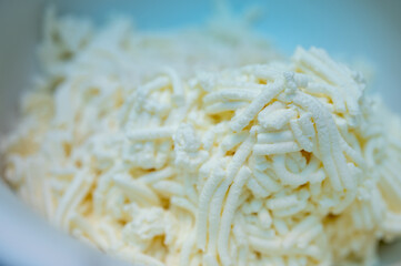 Homemade cow's cheese, ground. Cheese in a bowl. Soft cheese in a white tall bowl. Selective focus