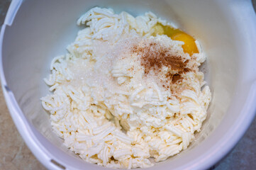 Homemade cow's cheese, ground, egg, homemade cheesecakes. Cheese in a bowl. Soft cheese in a white tall bowl. Selective focus