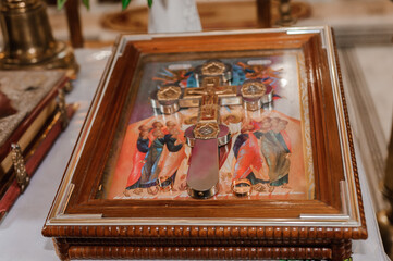 Pair of golden wedding rings on the icon near the cross