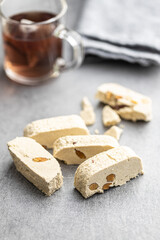 Sweet tahini halva with almonds. Turkish dessert gray table.
