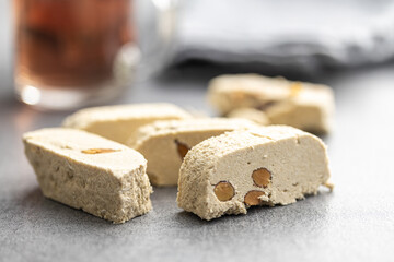 Sweet tahini halva with almonds. Turkish dessert gray table.