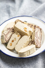 Sweet tahini halva with cocoa flavor and almonds. Turkish dessert on plate.