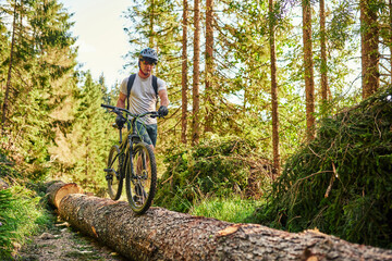 Fototapeta na wymiar Cyclist Riding the Bike on the Trail in the Forest. Man cycling on enduro trail track. Sport fitness motivation and inspiration. Extreme Sport Concept. Selective focus