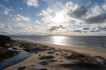 the beach and the blue water of the Baltic Sea and the sky is bluespring. Latvia.