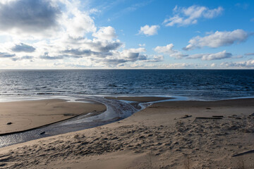 the beach and the blue water of the Baltic Sea and the sky is bluespring. Latvia
